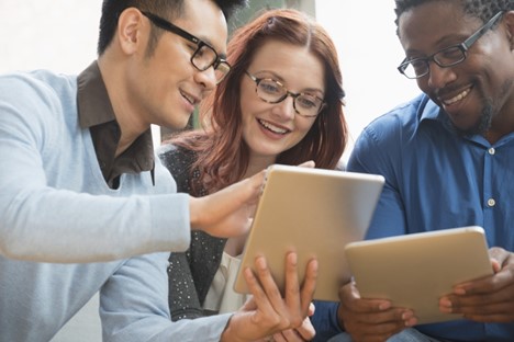 A group of people confer over tablets